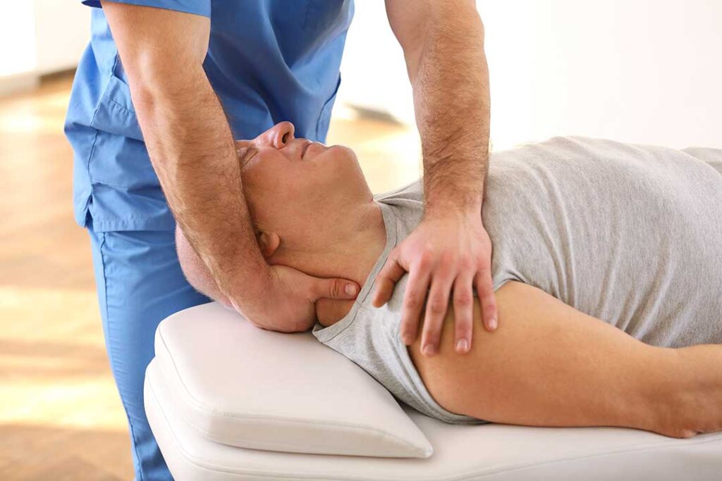 Chiropractor demonstrating spinal alignment to a patient using a model of the human spine.