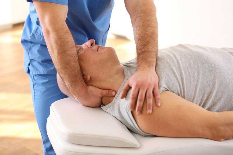 Chiropractor demonstrating spinal alignment to a patient using a model of the human spine.